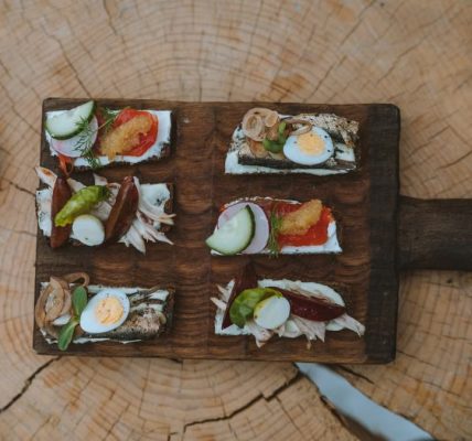 Top view of holiday appetizers on a wooden board with festive elements, creating a cozy rustic feel.