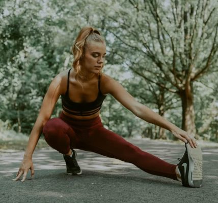 Full length of focused female athlete doing lunges forward while stretching legs in park